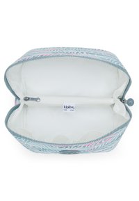 Kipling zippered fack med en ljusblå utsida med ett lövmönster i rosa och grönt. Inuti är den krämfärgad med ett dragkedjefack.
