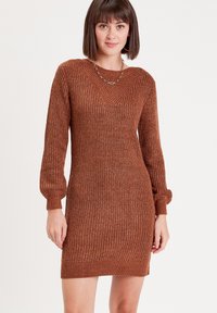 Vestido de punto marrón con mangas largas y abullonadas y escote en forma de V. Textura de canalé y diseño ajustado, que termina por encima de la rodilla.