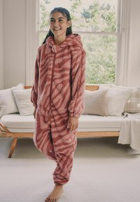 Fuzzy pink onesie with a hood, featuring a muted stripe pattern, long sleeves, elastic cuffs, and a front zipper. Soft texture.