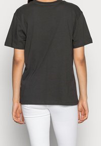 Mørkegrå bomulds-t-shirt med korte ærmer, rund halsudskæring og ensartet design. Stoffet ser blødt ud med standard syninger.