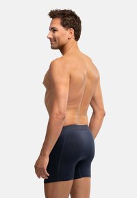 Granatowe bokserki wykonane z gładkiego, elastycznego materiału, z szerokim elastycznym pasem i subtelnymi detalami szwów.