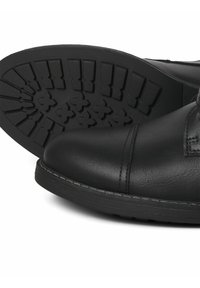 Bottes en cuir noir avec un bout arrondi, des détails cousus et une semelle extérieure en caoutchouc texturé avec un motif de croix pour une meilleure adhérence.