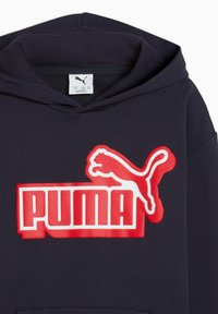 Sweat à capuche bleu marine avec un grand logo "PUMA" rouge bordé de blanc. Il comprend une poche kangourou et une capuche avec cordon de serrage. Le tissu semble lisse.