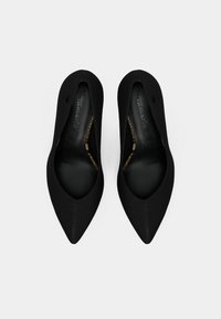 Μαύρα παπούτσια με μυτερή μύτη, με κομψό υφασμάτινο επάνω μέρος και μαλακή δερμάτινη επένδυση, με εμφανή ραφή κατά μήκος των ραφών.