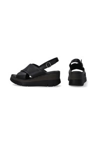 Zwarte leren wedge sandalen met kruisriemen en een gesp. Gekartelde donkerbruine platformzool en open rugontwerp.