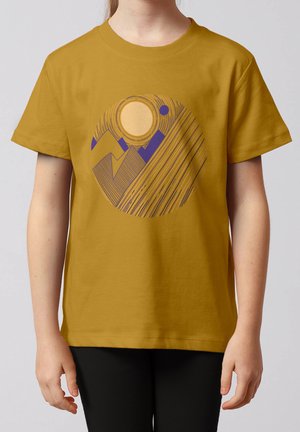 Kind trägt ein senfgelbes T-Shirt mit einem geometrischen Design von Bergen und einer Sonne, dargestellt durch lila und orangefarbene Linien.