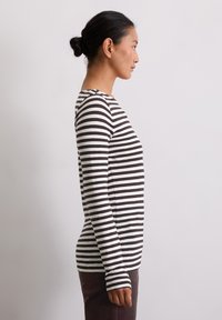 Langarmshirt in zwart-witte strepen, gemaakt van zachte stof, met een ronde halslijn en een getailleerd ontwerp.