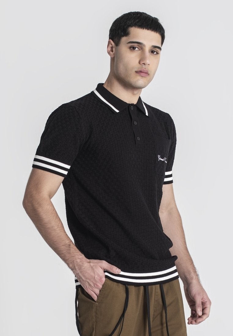 Černé polo tričko s texturou, bíle pruhovaný límec a manžety, s kapsou a vyšitým detailem na hrudi.