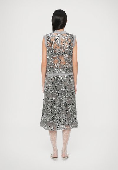 Φόρεμα χωρίς μανίκια σε γκρι χρώμα από διαφανές ύφασμα, διακοσμημένο με ασημένιες παγιέτες σε λουλουδένια σχέδια, με φθαρμένο τελείωμα και κλείσιμο στο πίσω μέρος.