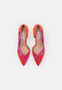 Escarpins en suède rouge et orange à bout pointu avec une sangle élastique rose sur le dessus ; intérieur lisse avec une semelle intérieure estampillée.