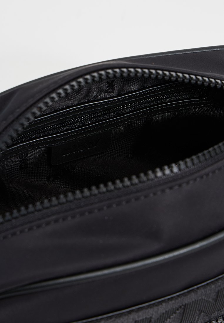 Bolsa de hombro de nailon negra con cierre de cremallera, con un exterior liso, bolsillo interno con cremallera y detalle del logo de la marca en el interior.