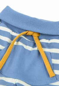Ceinture de pantalon rayée bleu et blanc avec une poche bleue et un cordon jaune noué sur une ceinture élastique bleue côtelée.