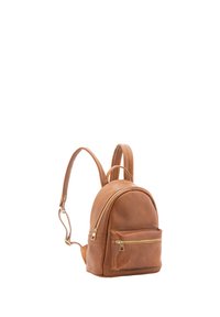 Zaino in pelle marrone dalla forma arrotondata, con una tasca frontale con zip e spallacci regolabili doppi. Accenti in metallo dorato visibili sulla zip.