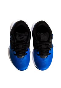 Zapatilla azul con parte superior de cuero texturizado, cordones negros y cuello acolchado. Suela de goma blanca con agujeros de ventilación en el área de los dedos.