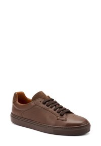 Sneaker en cuir marron avec des accents en daim, bout rond et semelle en caoutchouc texturé. Présente des lacets marron foncé et un intérieur marron clair.