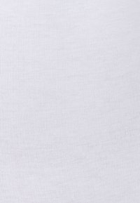 Tessuto bianco a coste con una superficie liscia, caratterizzato da sottili linee verticali. Il materiale appare morbido e elastico, adatto per abbigliamento aderente.