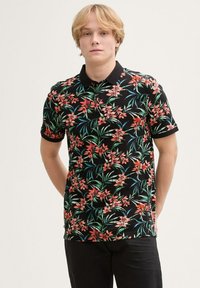Czarna koszulka polo z żywym wzorem kwiatowym, z różowymi kwiatami i zielonymi liśćmi. Krótkie rękawy i klasyczny krój kołnierzyka.