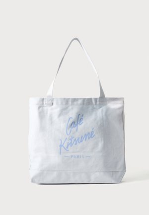 Tote bag en toile blanche avec longues anses, avec un texte bleu clair « Café Kitsuné Paris » sur le devant.