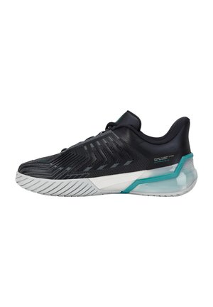 Chaussure de sport noire avec motifs texturés, semelle blanche et accents bleu sarcelle, vue de côté sur fond blanc.