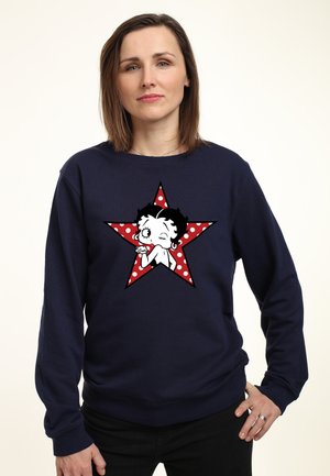 Mørkeblå sweatshirt med et centralt grafisk motiv af en tegneseriefigur på en rød stjerne med hvide prikker. Lavet af bomuldsstof, afslappet pasform.