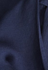 Donker marineblauwe stof met een gladde textuur, met subtiele weefpatronen en schone, rechte randen. Close-up weergave laat gedetailleerde stiksels zien.