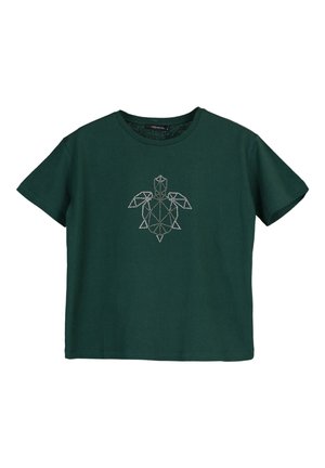 T-shirt en coton vert foncé avec un design géométrique de tortue blanche sur le devant. Manches courtes et col rond.