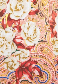 Kräm- och guldrosor med röda löv över ett mångfärgat intrikat paisleymönster i röd, orange, blå och grön på tyg.