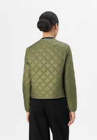 Quilted olive green jacket with long sleeves, round neck, and elastic cuffs. Features a smooth texture and diagonal stitching pattern.
