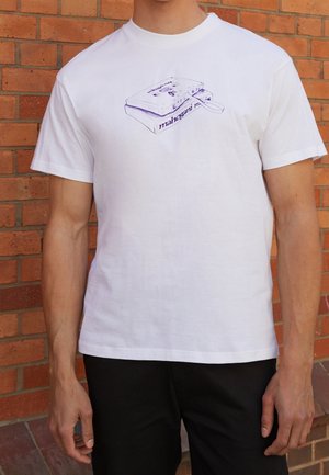 Hvid bomulds t-shirt med et lilla grafik af en vintage kassetteafspiller og teksten "mahogany." Korte ærmer, rund hals.
