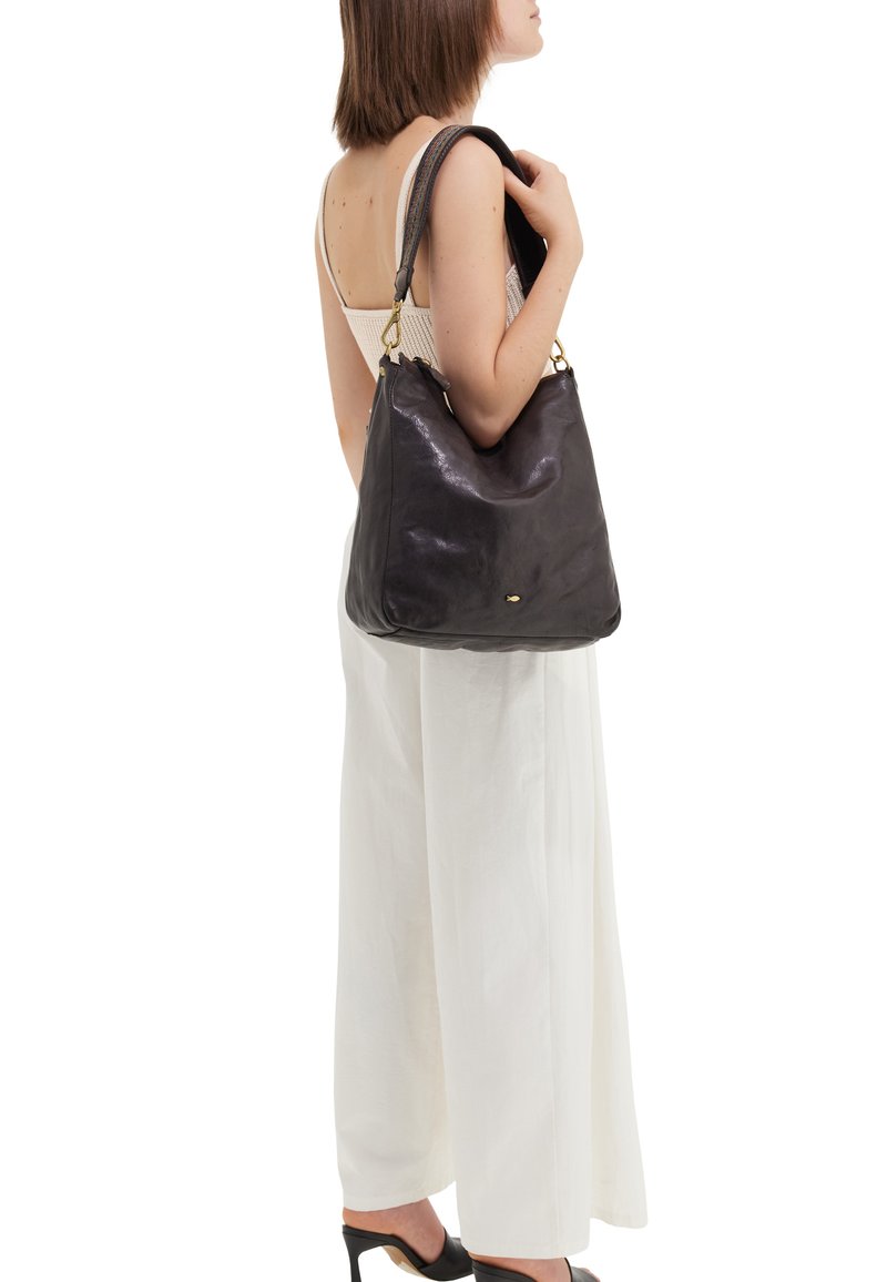 Borsa a spalla in pelle nera con texture liscia, forma arrotondata e dettagli in metallo dorato. La tracolla presenta cuciture decorative.