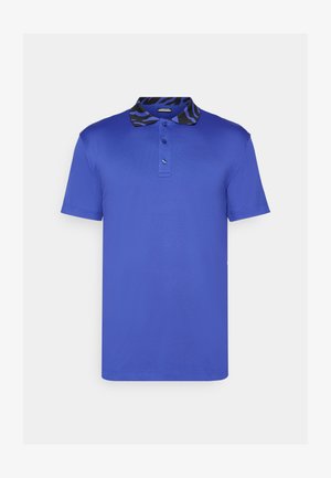 Mėlynas polo marškinėlis su trumpomis rankovėmis, trijų mygtukų apykaklė ir juoda bei mėlyna raštuota vidinė apykaklė. Lygus audinys, įprastos formos dizainas.