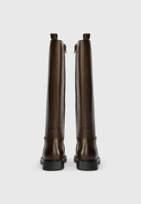 Brown leather knee-high boots with a smooth finish, side zippers, and a reinforced sole, featuring minimal detailing and a structured shape.