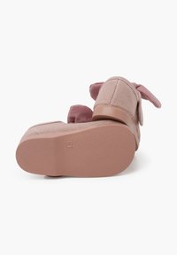 Zapatos de tela rosa con una parte superior texturizada, que cuentan con orejas de conejo en el talón y una suela de goma suave. Talla marcada como 21 en la parte inferior.