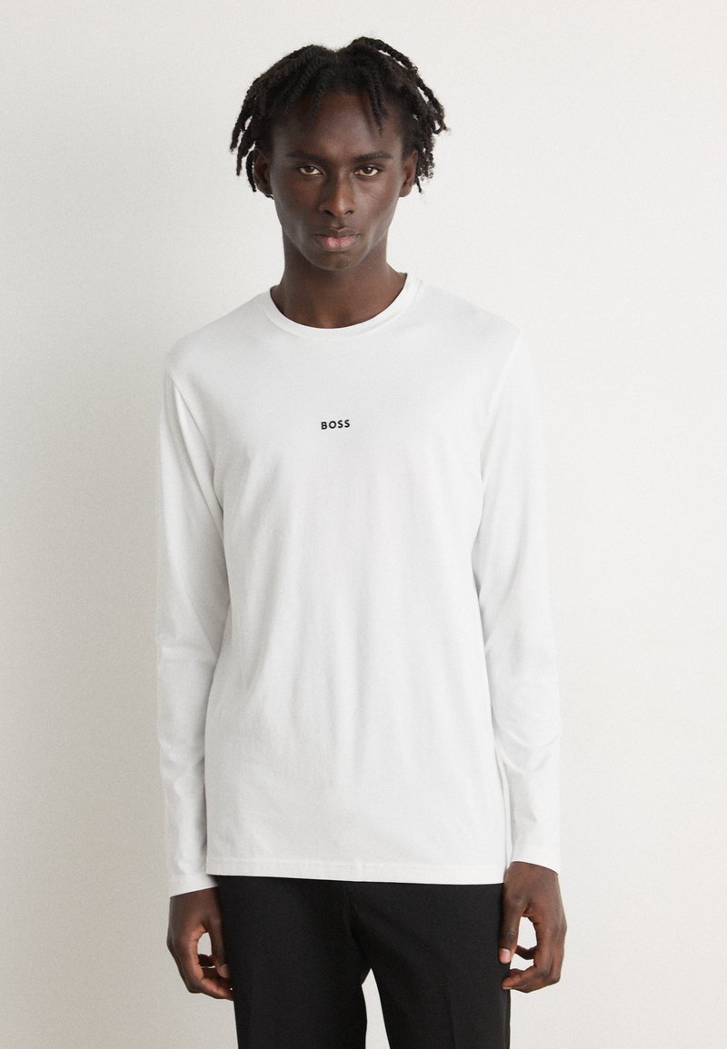 Camiseta de manga longa branca em algodão, com decote redondo e pequeno logotipo preto "BOSS" no centro do peito.