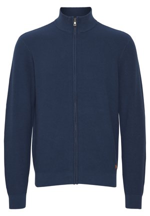Maglione zip-up blu navy con texture a costine, colletto alto e polsini aderenti. Presenta un leggero accento del logo sulla parte inferiore.