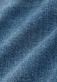 Tissu en denim bleu avec un tissage fin, présentant une texture lisse et des détails subtils dans des nuances de bleu variées.