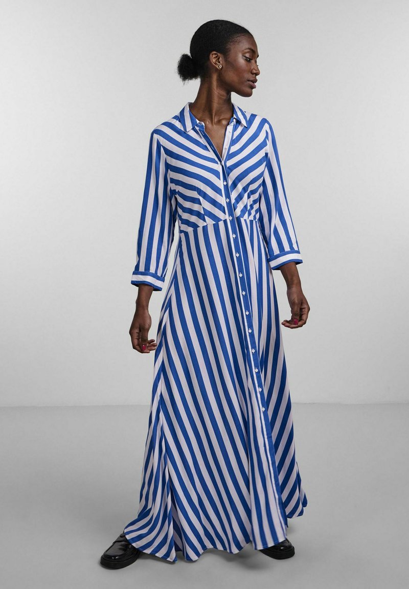 Long button-up dress with blue and white vertical stripes, long sleeves, collar, and a flowing skirt. Smooth fabric with a relaxed fit.