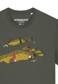 Donkergroene t-shirt met een speelse ontwerp van gnooms in een landschap van gaten, gele aarde, groene gras en rode paddenstoelaccenten.