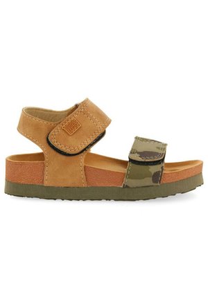 Sandalia de cuero marrón con tiras de camuflaje, plantilla texturizada, cierres ajustables de velcro y suela de goma verde. Diseño ligero y abierto.