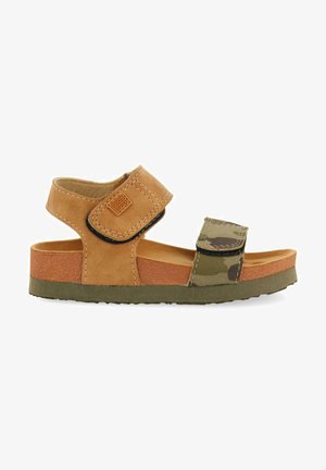 Sandalia de cuero marrón con tiras de camuflaje, plantilla texturizada, cierres ajustables de velcro y suela de goma verde. Diseño ligero y abierto.