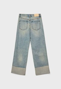 Svijetloplave traper široke hlače s preklopom na rubu. Imaju dvije stražnje džepove i oznaku brenda na pojasu.