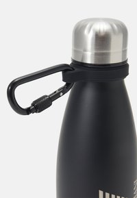 Bouteille d'eau en acier inoxydable noir avec un capuchon en métal argenté et un mousqueton noir. Fini mat lisse, design élancé et sans motifs visibles.