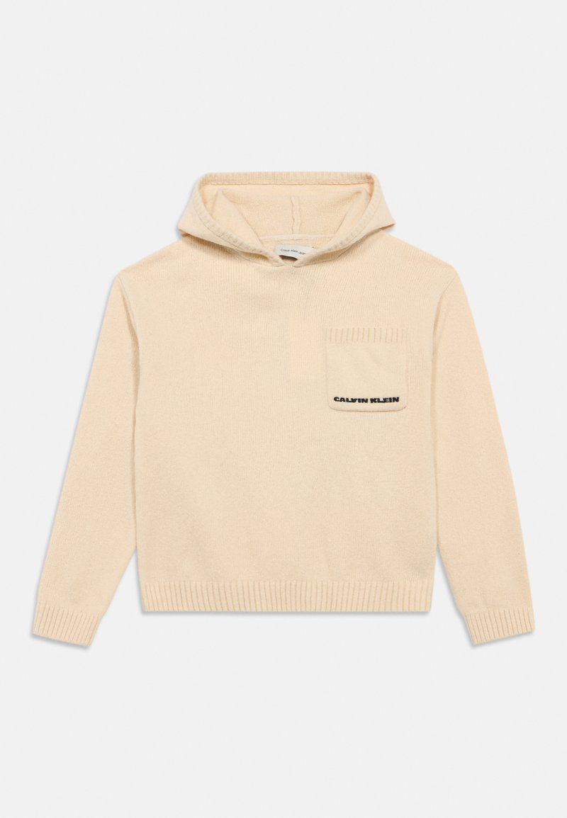 Krämfärgad hoodie med känguruficka, ribbstickade muddar och nederkant. Tyget ser mjukt och strukturerat ut med en logotyp i mörk skrift.