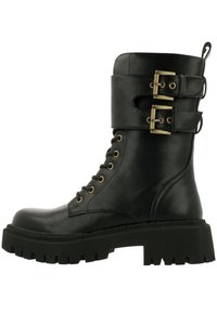 Bota negra de cuero hasta el tobillo con parte delantera de cordones, dos correas con hebillas y una suela de goma negra gruesa con textura estriada.