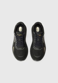 Black athletic sneakers with mesh and synthetic upper, flat laces, cushioned sole, and gold accents on the side.