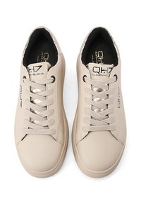 Sneakers in pelle beige con texture liscia, lacci piatti e dettagli dorati sulla linguetta. Presentano un design del logo minimalista e punta rotonda.