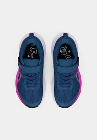Blue athletic shoes with a textured upper, pink accents on the sole, and a Velcro strap over the laces. Black patterned insoles.