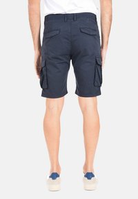 Pantaloni cargo navy con più tasche laterali e tasche posteriori applicate. Realizzati in tessuto liscio, di lunghezza al ginocchio con taglio dritto e passanti per cintura.