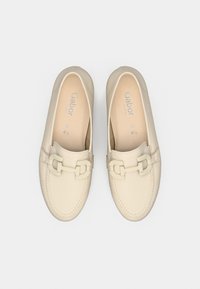 Δερμάτινα παπούτσια slip-on σε ανοιχτό μπεζ χρώμα, με διπλή αγκράφα διακοσμητική λεπτομέρεια, στρογγυλεμένη μύτη και υφασμένες ραφές κατά μήκος των άκρων.