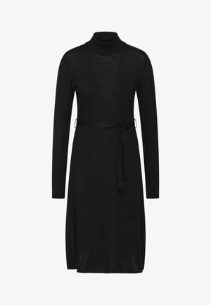 Černé pletené šaty s vysokým límcem, dlouhými rukávy, páskem v pase, bočními rozparky a jemným zlatým knoflíkem na rameni.